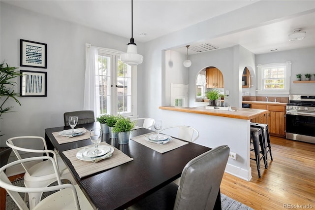 1838 S Williams St, Denver, CO 80210 - dining area featuring light wood-style floors and arched walkways