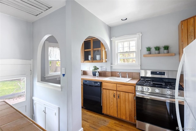1838 S Williams St, Denver, CO 80210 - kitchen with stainless steel gas range, dishwasher, light wood-type flooring, light countertops, and freestanding refrigerator