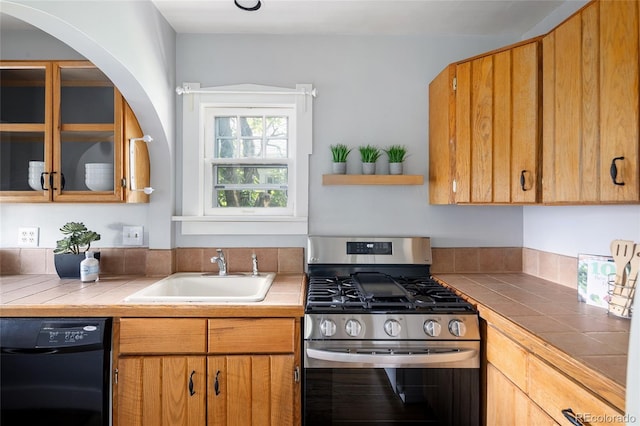 1838 S Williams St, Denver, CO 80210 - kitchen featuring stainless steel range with gas stovetop, black dishwasher, tile counters, glass insert cabinets, and arched walkways