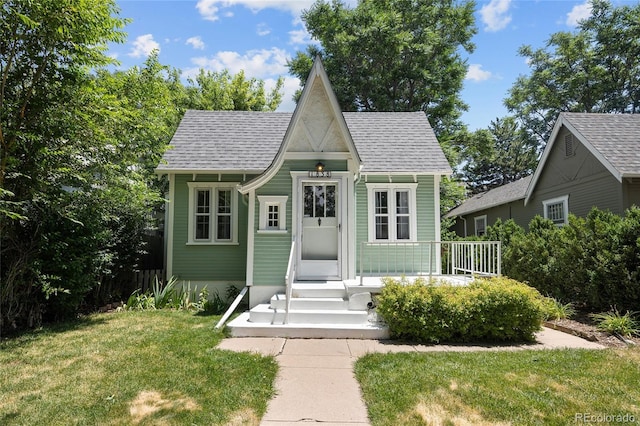 1838 S Williams St, Denver, CO 80210 - view of front of house featuring an outbuilding, a front yard, and roof with shingles