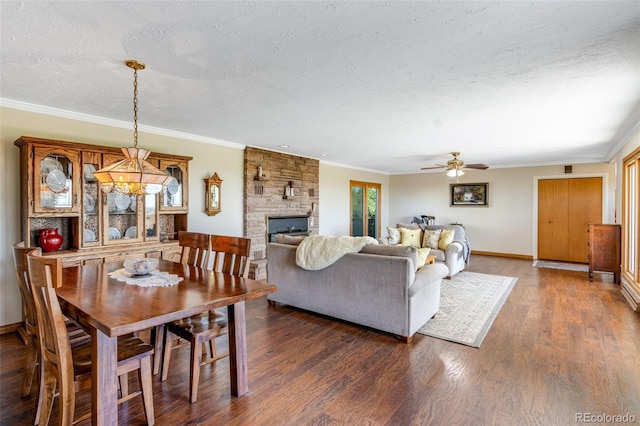 12891 County Road 29, Sterling, CO 80751 - dining space with a textured ceiling, a fireplace, dark wood-type flooring, ceiling fan, and crown molding