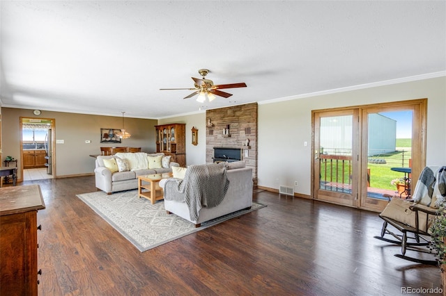12891 County Road 29, Sterling, CO 80751 - living area with ornamental molding, dark wood-type flooring, ceiling fan, and a stone fireplace