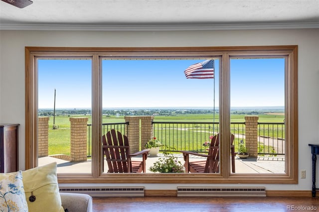 12891 County Road 29, Sterling, CO 80751 - interior space featuring a baseboard radiator, wood finished floors, crown molding, baseboard heating, and a rural view
