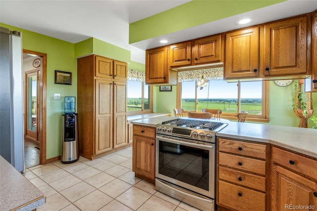 12891 County Road 29, Sterling, CO 80751 - kitchen with stainless steel gas stove, brown cabinetry, light countertops, and light tile patterned flooring