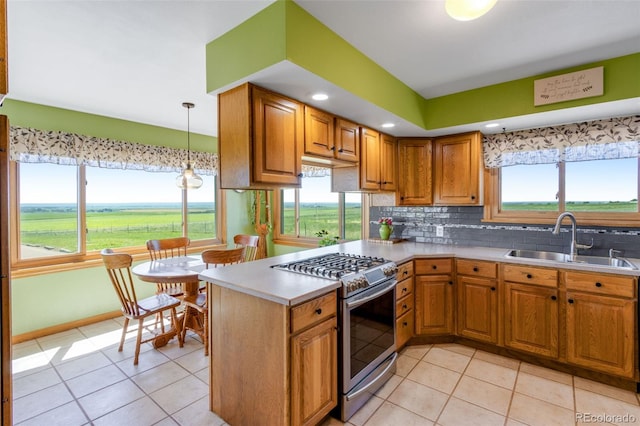 12891 County Road 29, Sterling, CO 80751 - kitchen featuring stainless steel range with gas cooktop, light tile patterned flooring, brown cabinets, a peninsula, and recessed lighting