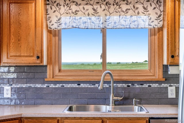 12891 County Road 29, Sterling, CO 80751 - kitchen featuring light countertops, backsplash, and brown cabinets