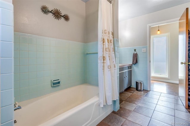 12891 County Road 29, Sterling, CO 80751 - full bathroom with tile walls, shower / bath combo with shower curtain, a wainscoted wall, and tile patterned floors