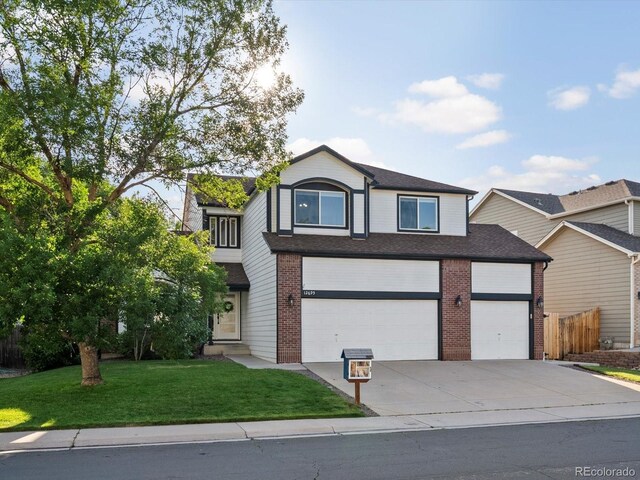 12695 Wolff St, Broomfield, CO 80020 - view of front of house with driveway, an attached garage, brick siding, and roof with shingles