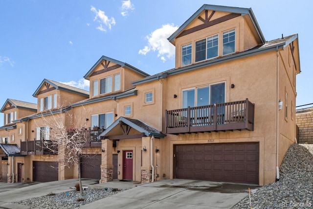 view of front of property with a garage, driveway, a balcony, and stucco siding