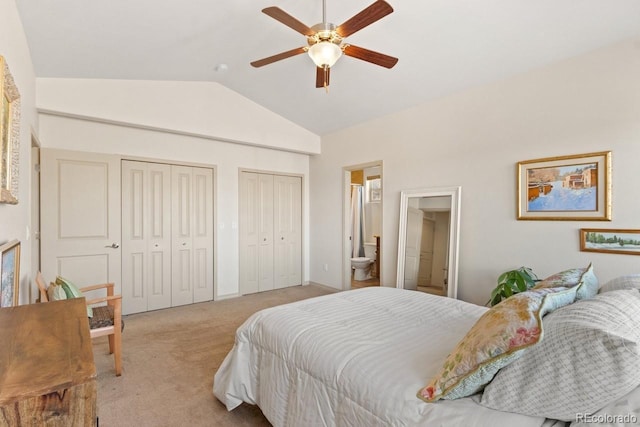 bedroom with multiple closets, light carpet, vaulted ceiling, ceiling fan, and ensuite bath