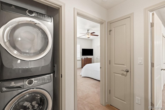 washroom with laundry area, light colored carpet, and stacked washing maching and dryer