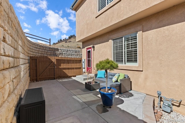 view of patio featuring a gate, fence, and a fire pit