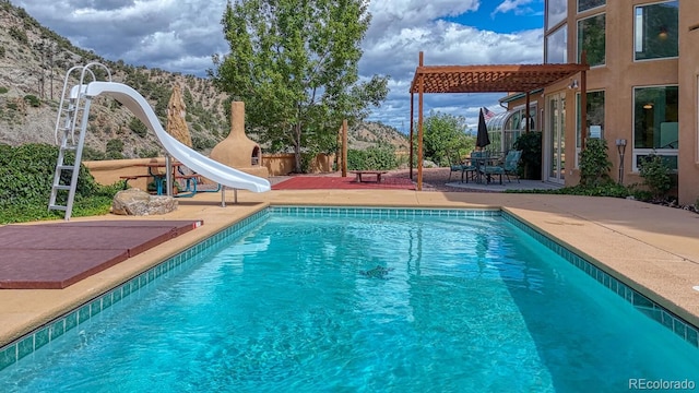 view of pool featuring a water slide and a patio area