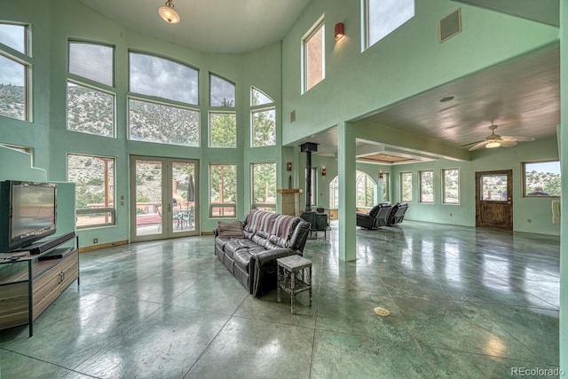 living room featuring ceiling fan, a wealth of natural light, and a towering ceiling