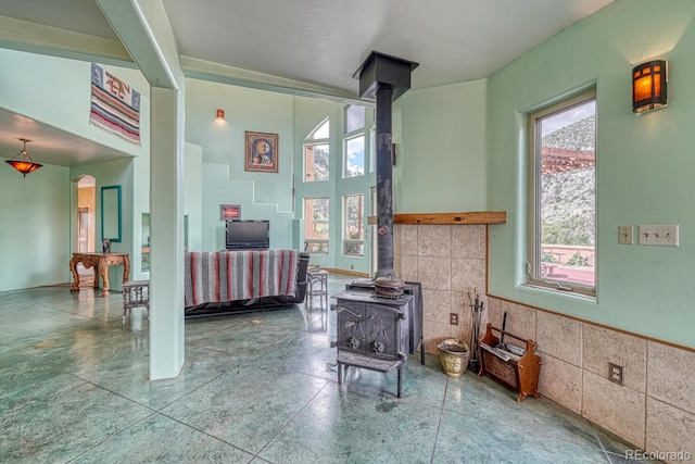 interior space with tile walls, plenty of natural light, and a wood stove