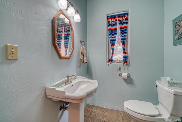 bathroom featuring toilet and tile patterned flooring