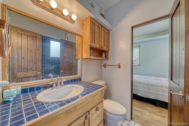 bathroom featuring hardwood / wood-style floors, toilet, a wealth of natural light, and vanity