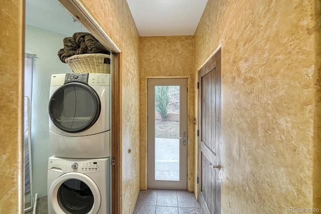 clothes washing area featuring stacked washing maching and dryer and light tile patterned floors