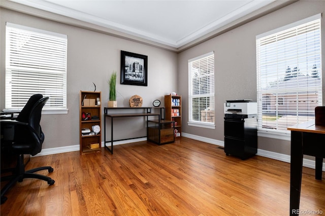 office area with light wood-style flooring, baseboards, and a healthy amount of sunlight