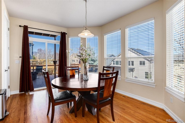 dining space featuring light wood-type flooring, baseboards, and visible vents