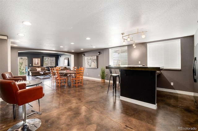 interior space with a textured ceiling, concrete floors, baseboards, and recessed lighting
