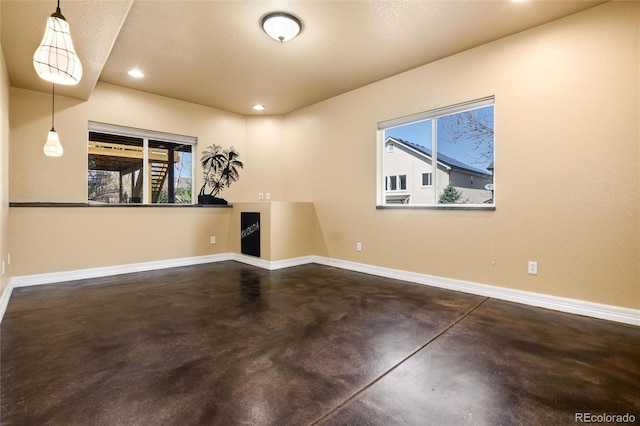 empty room featuring recessed lighting, finished concrete flooring, and baseboards