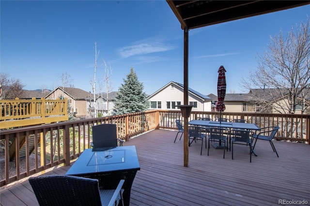 wooden deck with outdoor dining space and a residential view