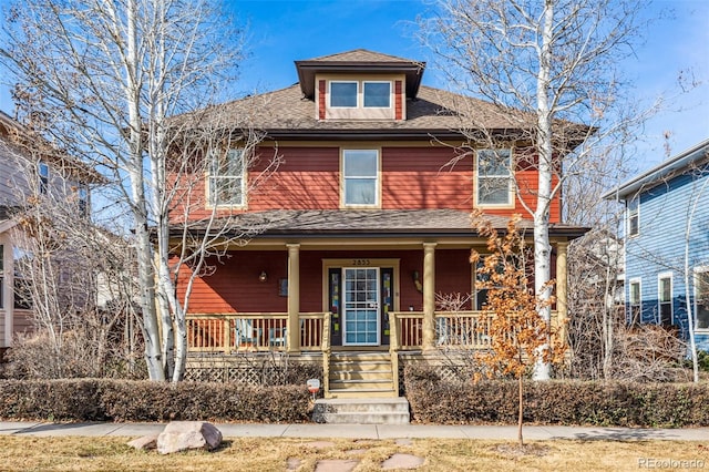 american foursquare style home featuring a shingled roof and covered porch