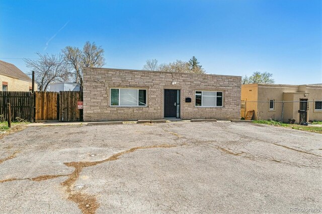 1050 S Quitman St, Denver, CO 80219 - view of front of home with stone siding, uncovered parking, and fence