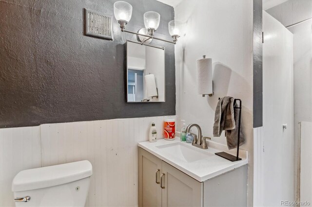 1050 S Quitman St, Denver, CO 80219 - bathroom featuring visible vents, toilet, and vanity