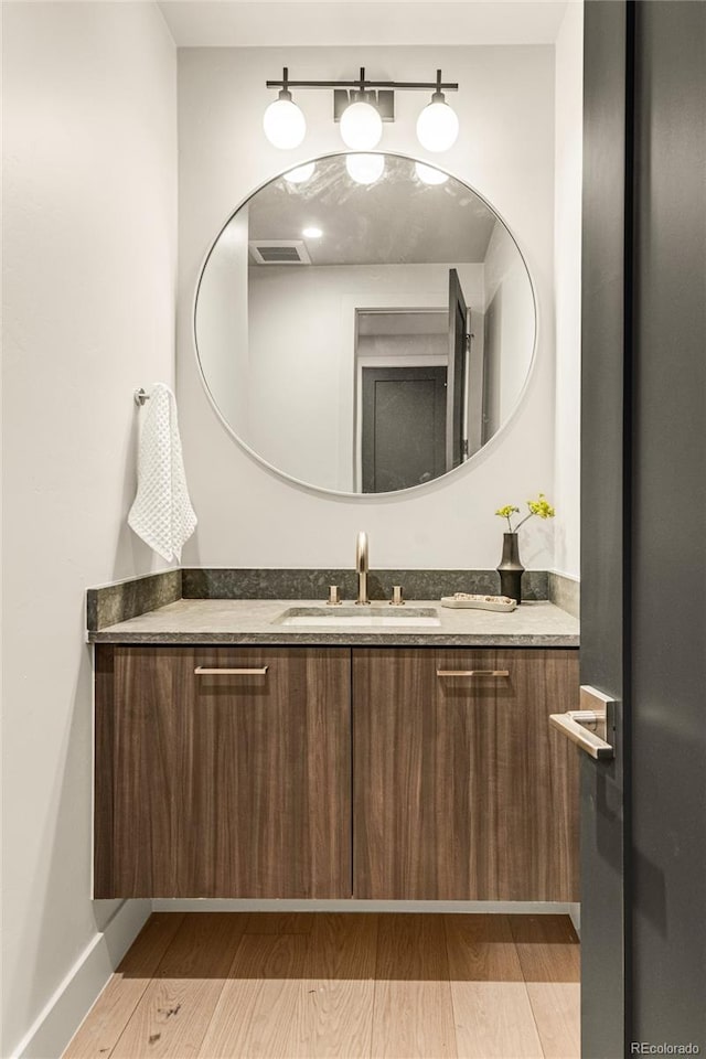 bathroom with hardwood / wood-style floors and vanity