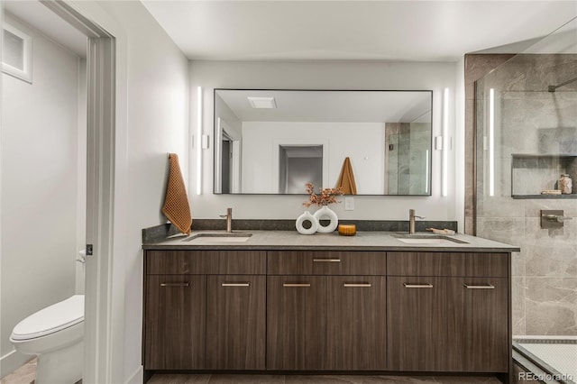 bathroom with vanity, toilet, and a shower with shower door