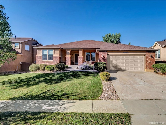 view of front of property featuring brick siding, driveway, an attached garage, and a front lawn