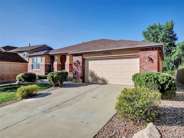 prairie-style home featuring concrete driveway, an attached garage, and brick siding