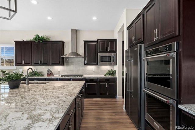 228 Rogers Ct, Castle Rock, CO 80104 - kitchen featuring wall chimney exhaust hood, stainless steel appliances, a sink, backsplash, and light stone countertops
