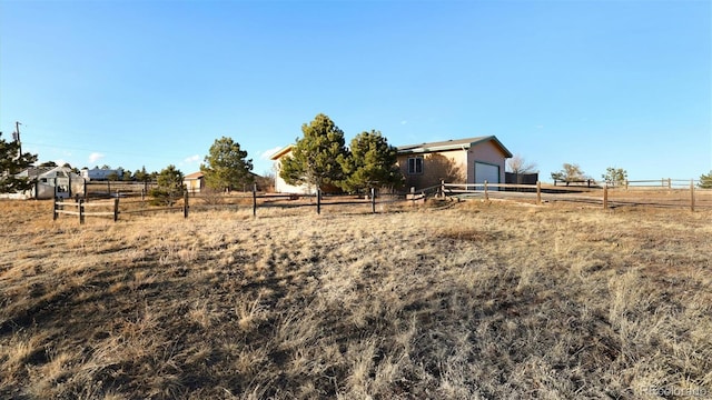 view of yard featuring a garage and a rural view