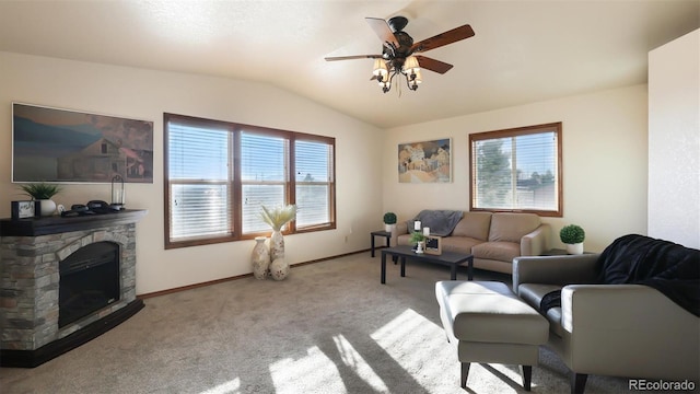 living room featuring a fireplace, light colored carpet, ceiling fan, and vaulted ceiling