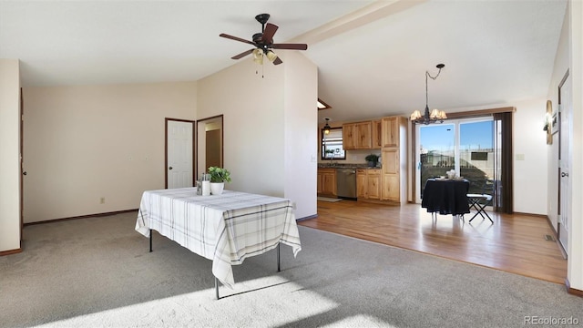 dining space with vaulted ceiling, ceiling fan with notable chandelier, and light colored carpet