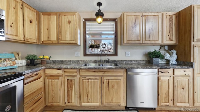 kitchen with stainless steel appliances, hanging light fixtures, sink, and light brown cabinets