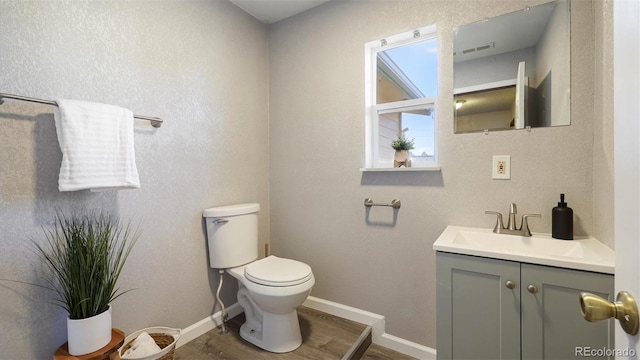 bathroom with vanity, hardwood / wood-style flooring, and toilet