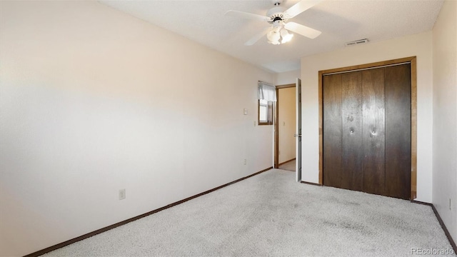 unfurnished bedroom with light carpet, ceiling fan, and a closet