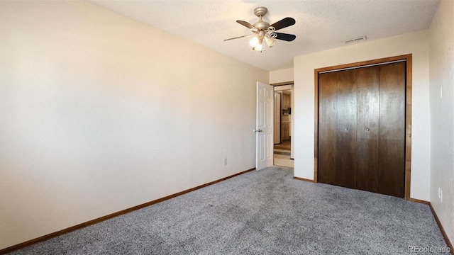 unfurnished bedroom featuring ceiling fan, a closet, carpet floors, and a textured ceiling