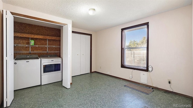 washroom with washing machine and clothes dryer and a textured ceiling