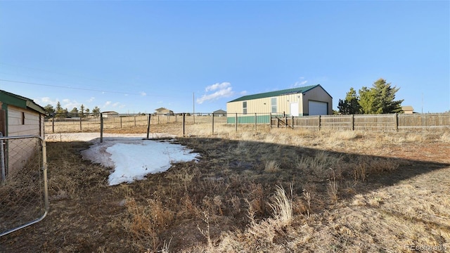 view of yard featuring a garage and a rural view