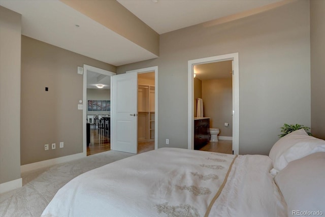 carpeted bedroom featuring connected bathroom, a spacious closet, and a closet