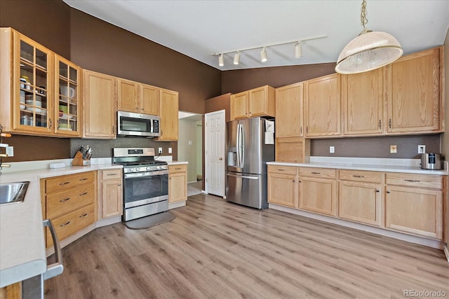 5932 S Versailles St, Aurora, CO 80015 - kitchen with stainless steel appliances, light brown cabinetry, track lighting, light wood finished floors, and light countertops