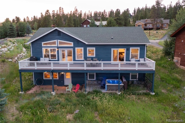 1624 Gcr 5221, Tabernash, CO 80478 - rear view of house with a hot tub, a wooden deck, a shingled roof, and a patio area