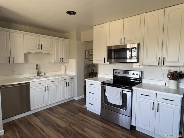 kitchen with white cabinets, decorative backsplash, a sink, and appliances with stainless steel finishes