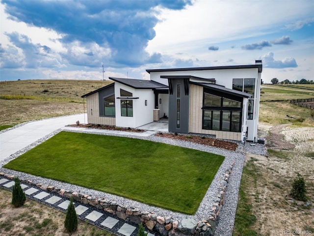 8765 Canyon Wind St, Parker, CO 80138 - back of house featuring a lawn, a sunroom, and concrete driveway