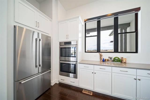 8765 Canyon Wind St, Parker, CO 80138 - kitchen with stainless steel appliances, wood tiled floors, and white cabinets